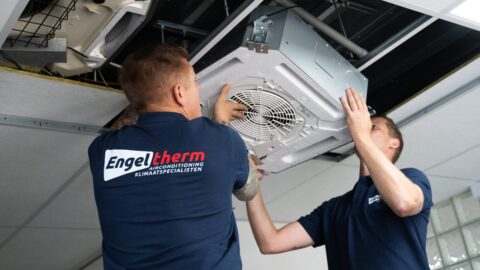 Twee medewerkers van Engeltherm plaatsen een airconditioning systeem een het plafond