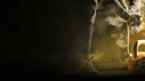 Decoratieve afbeelding: een sporter die in zijn handen slaat als voorbereiding op het optillen van een kogelgewicht